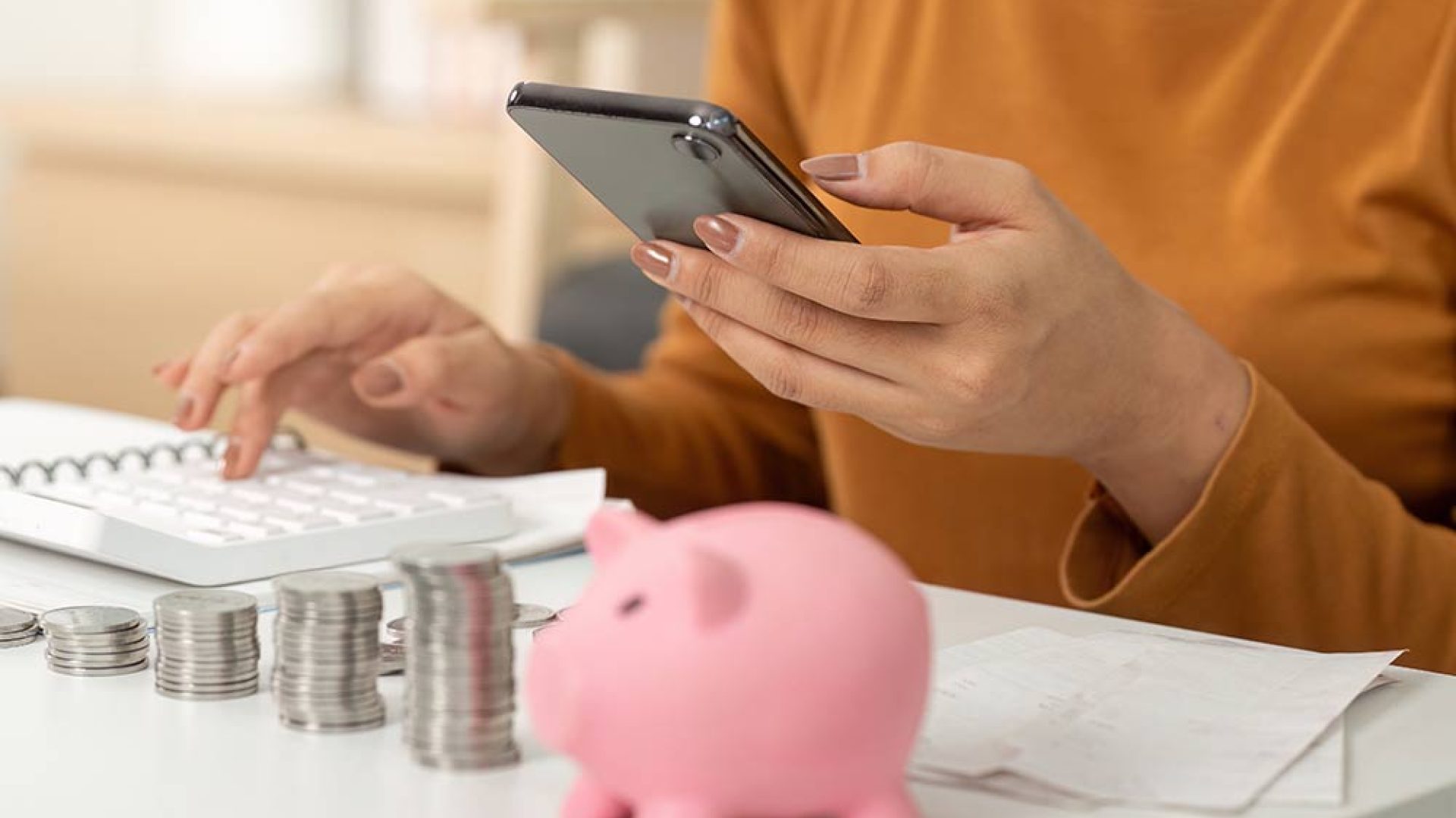 digital-finance-management-woman-using-smartphone-track-savings-with-piggy-bank-nearby