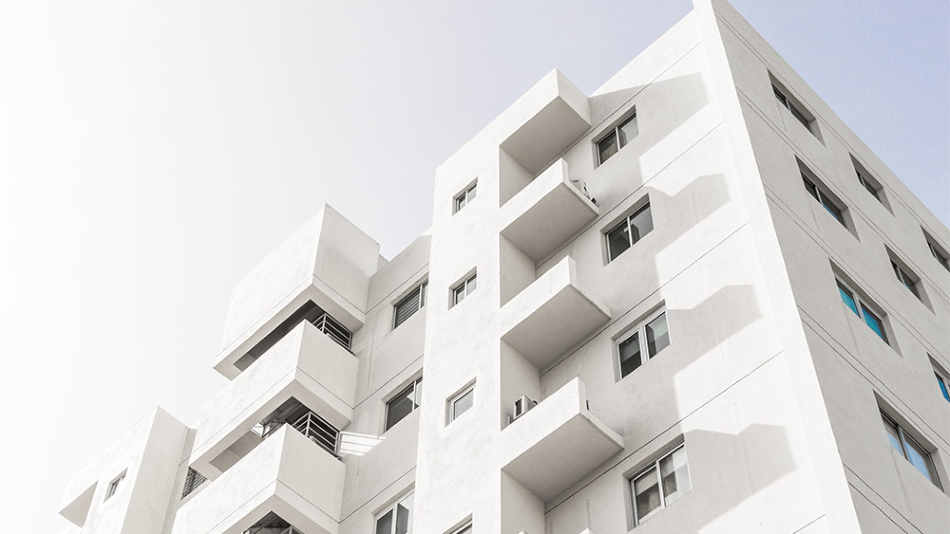 low-angle-shot-facade-white-modern-building-blue-clear-sky