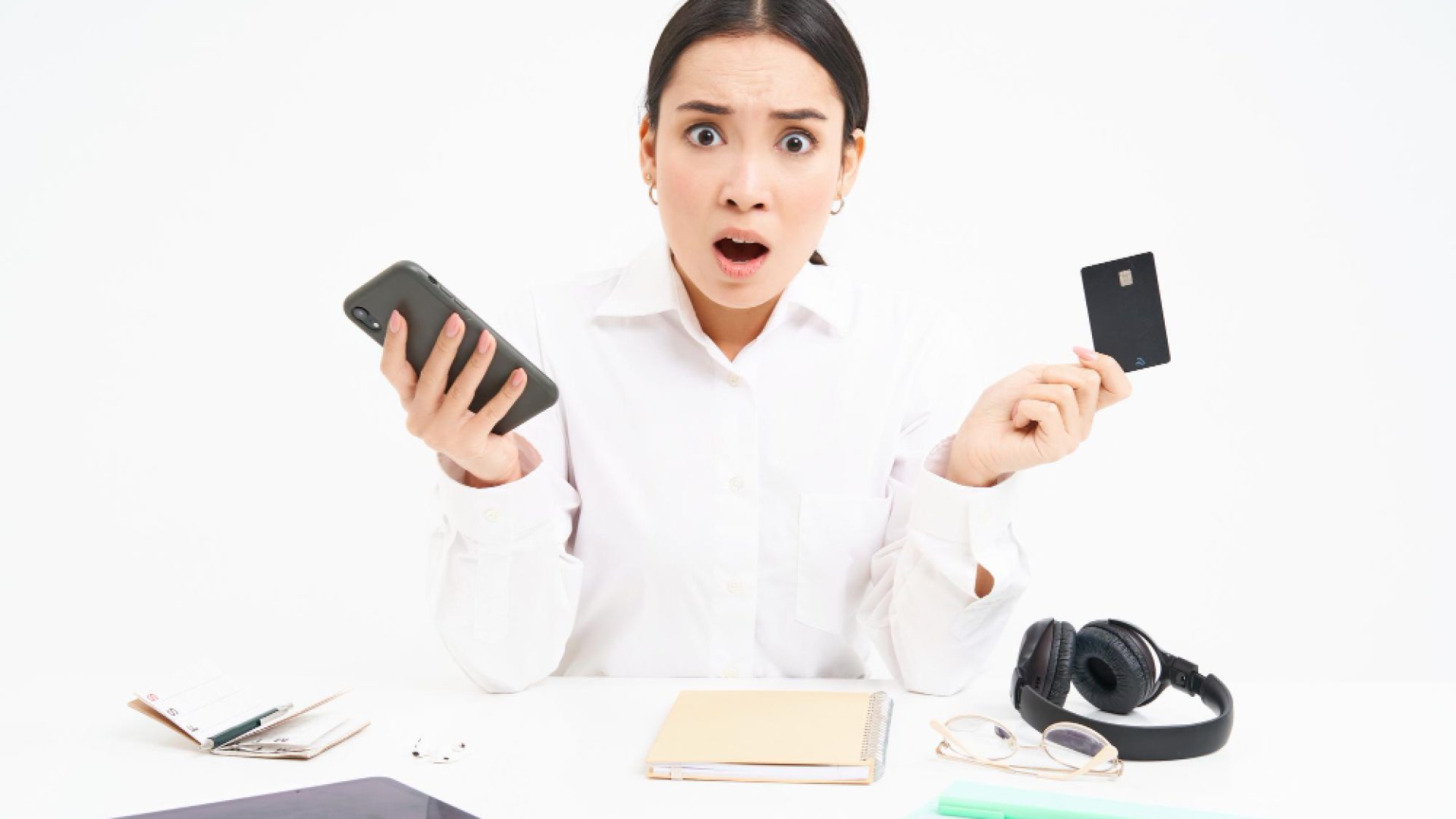 portrait-asian-woman-sits-table-holds-credit-card-smartphone-looks-upset-disappointed-by-p