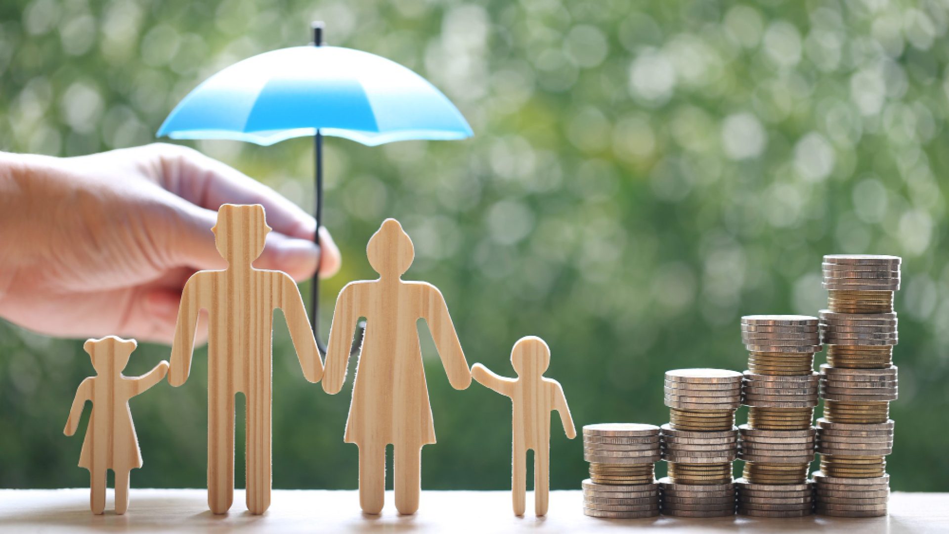 protection-model-family-with-hand-holding-umbrella-stack-coins-money-natural-green-background-finance-insurance-safe-investment-concept (1)