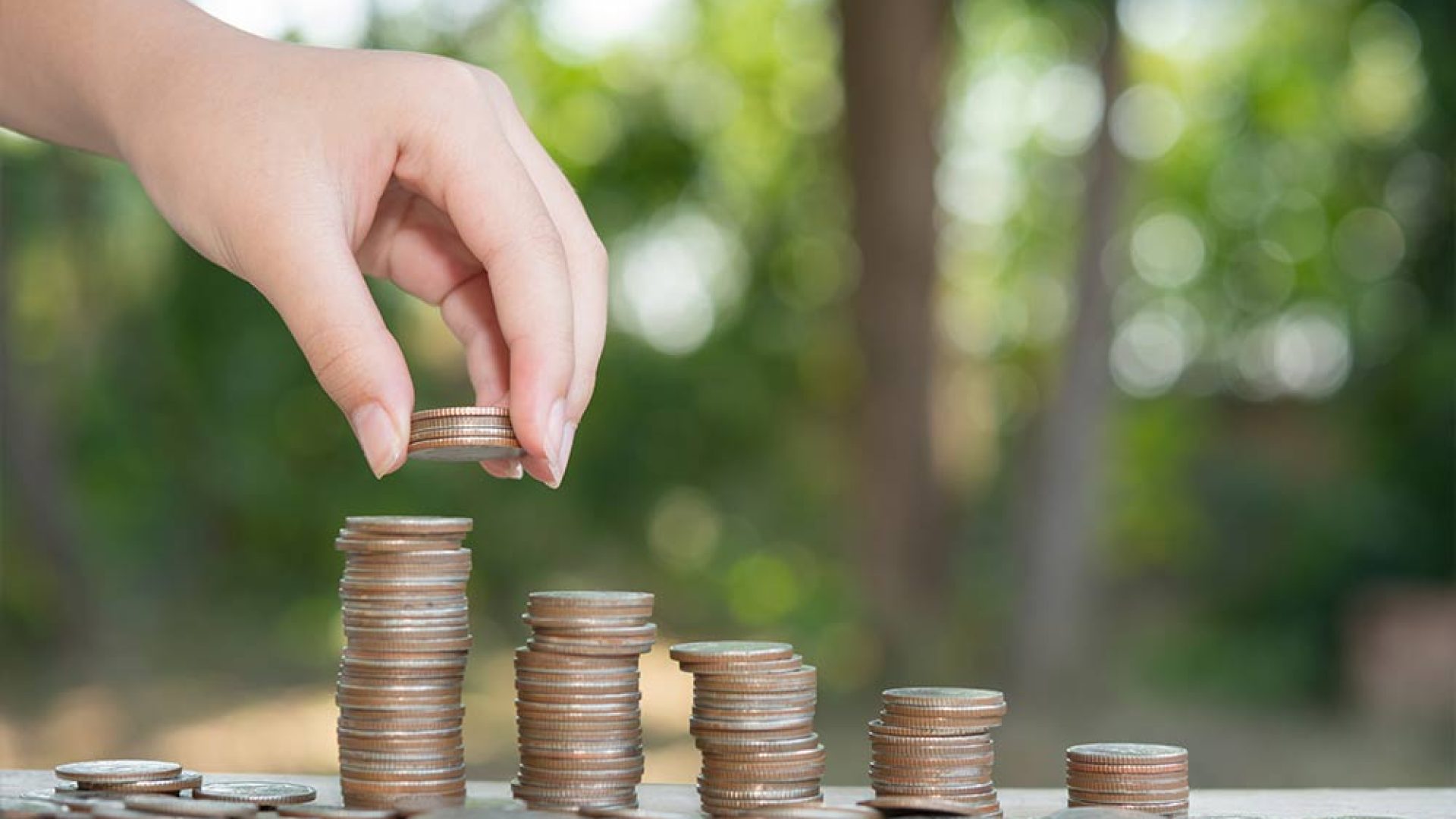 saving-money-concept-preset-by-male-hand-putting-money-coin-stack-growing-business-arrange-coins-into-heaps-with-hands-content-about-money