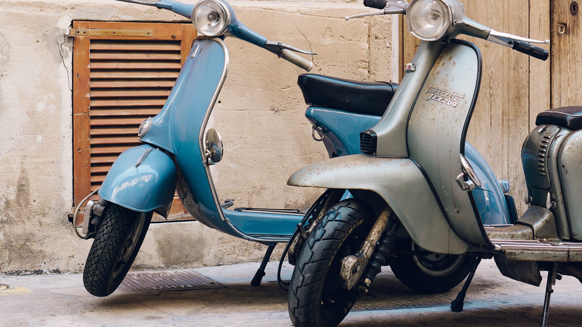 two-vintage-scooters-parked-street