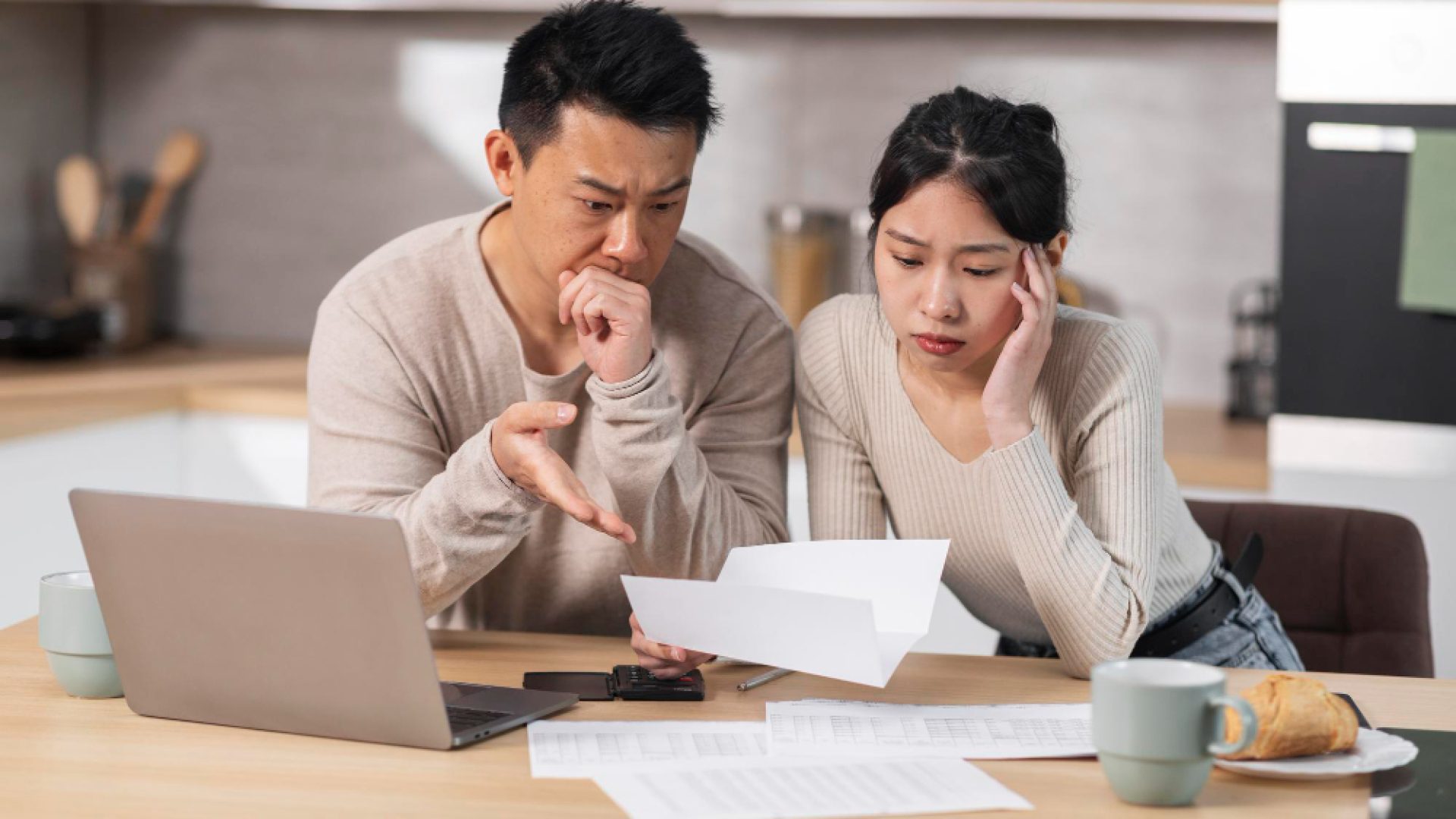 unhappy-asian-husband-wife-reading-letter-kitchen-interior