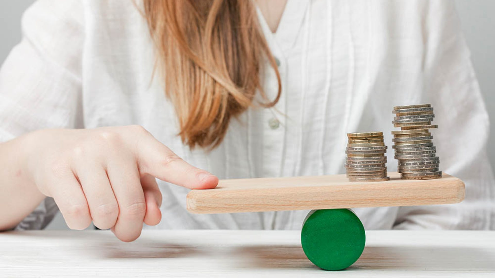 woman-holding-her-finger-balance-with-coins
